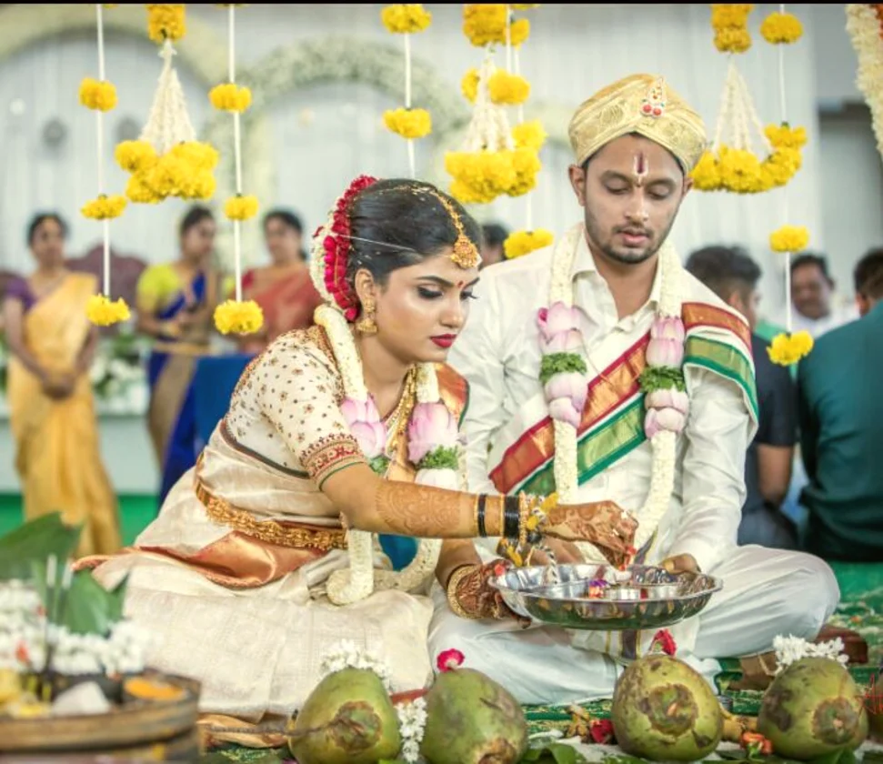 Couple during the wedding rituals with lotus garlands, Anubhandhaa Bangalore