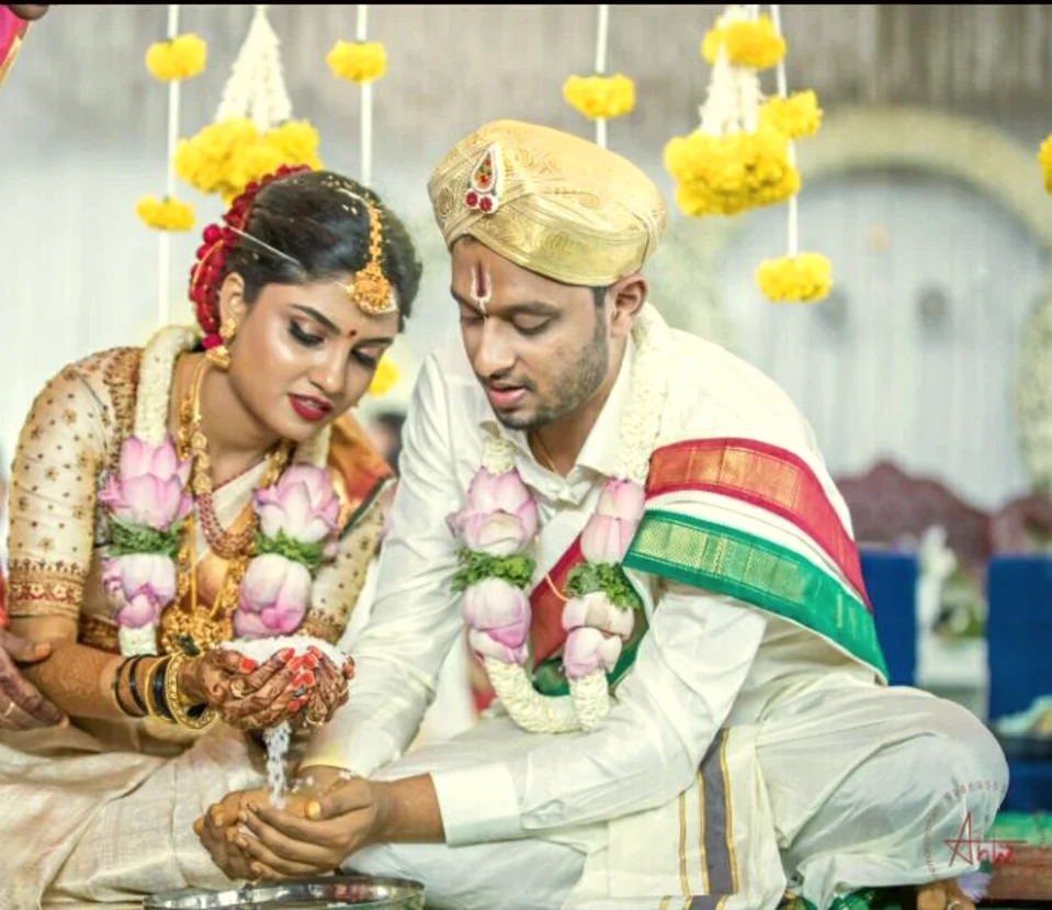 Couple at the sacred wedding rites beneath a marigold canopy, Anubhandhaa