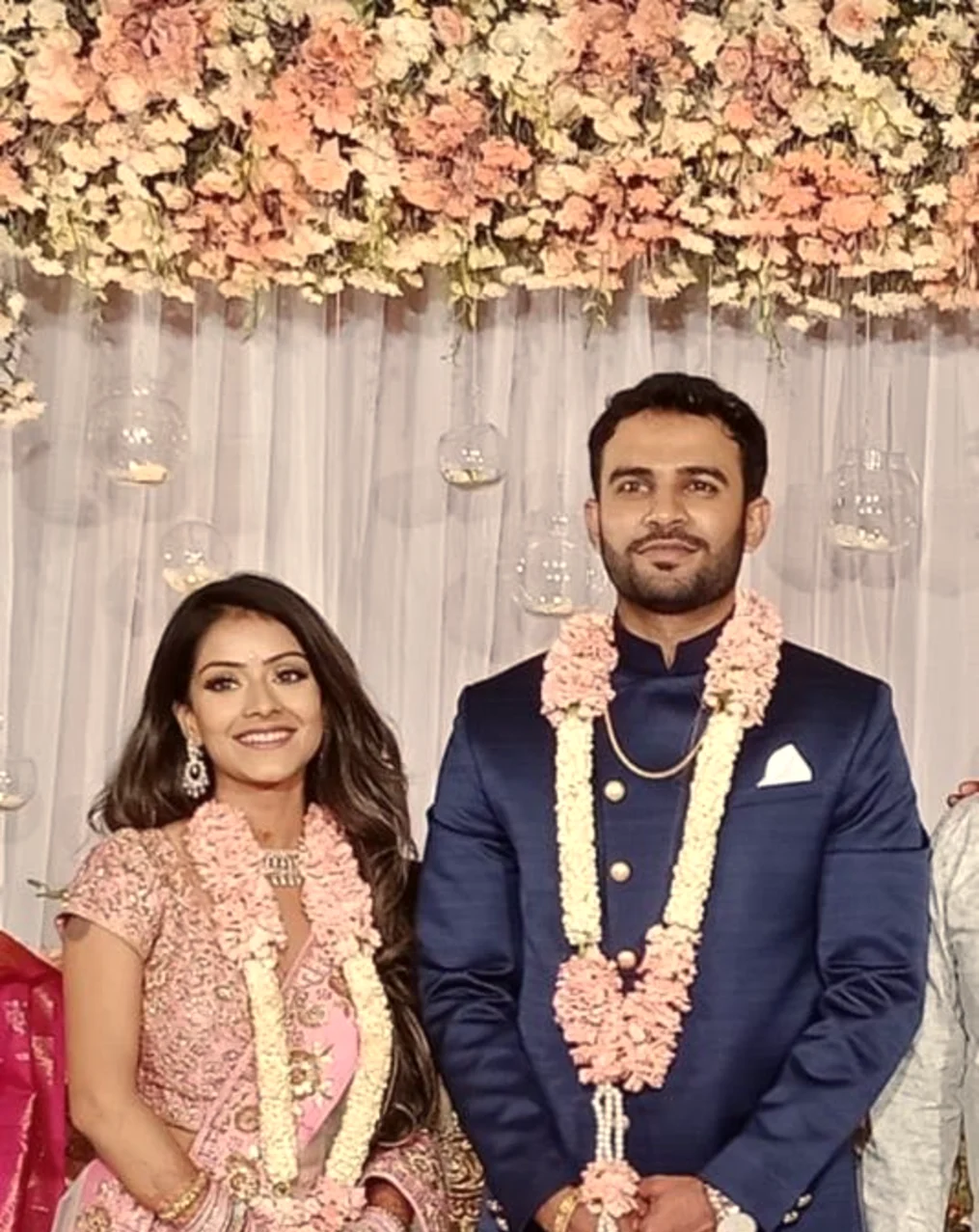 Bride and groom garlanded in pink at their reception, Anubhandhaa Bangalore